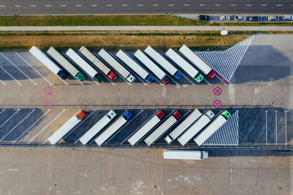 Semi-trailers lined up at the docks of a logistics centre near Poznań, drone view